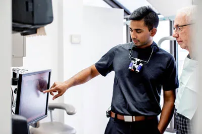 Dr. Gomes showing a patient their dental x-rays