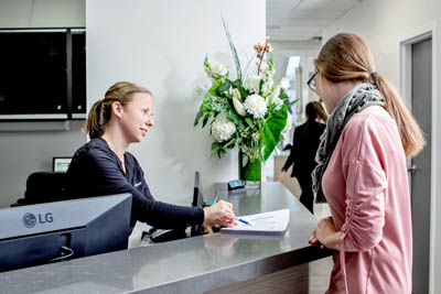 patient filling out her dental paperwork at Dentistry by the Bay